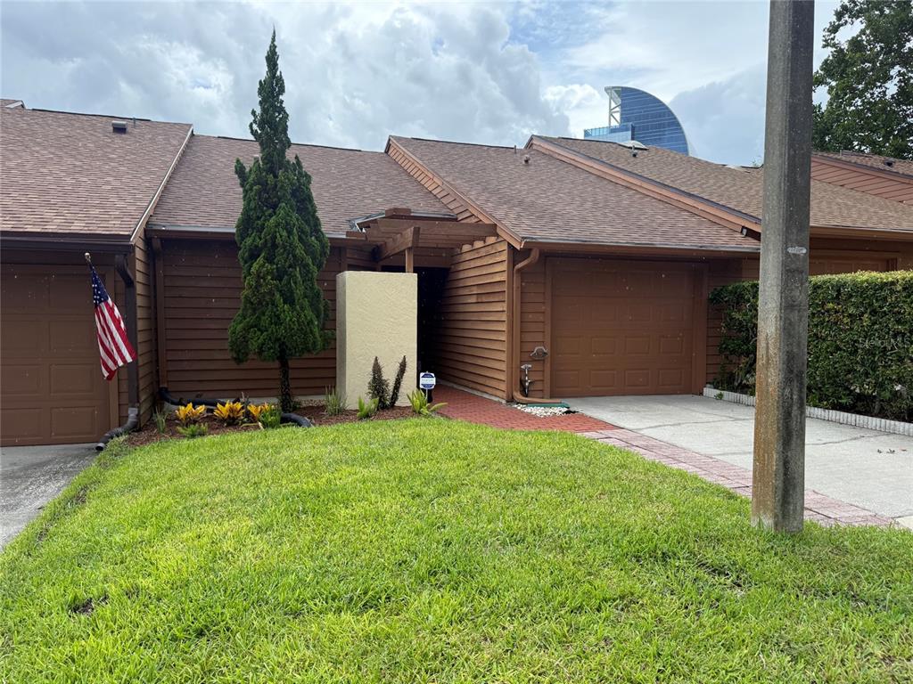 A brown-sided townhouse with a garage, a small front lawn, and a brick walkway — 204 TERN LANE, ALTAMONTE SPRINGS, FL