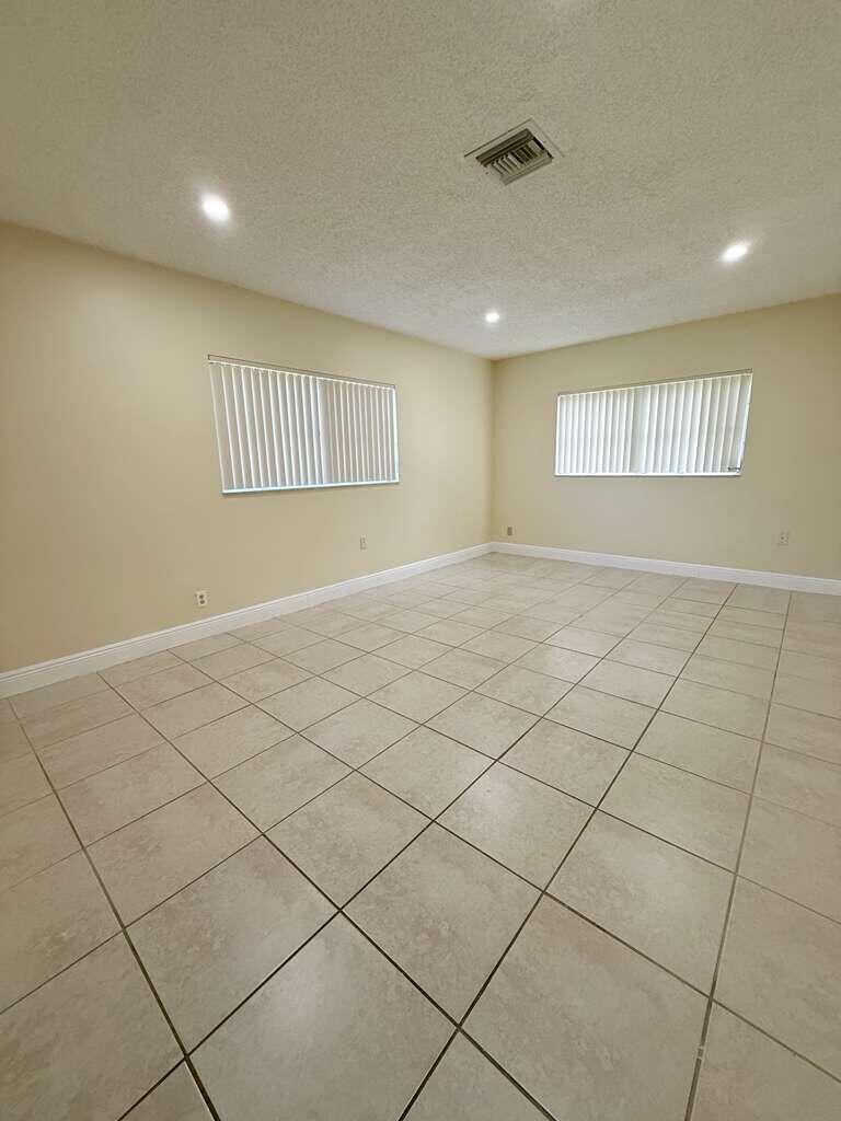 An empty room with beige walls, tile flooring, and two windows with vertical blinds — 1918 Palmland Drive # 2, Boynton Beach FL 33436, BOYNTON BEACH, FL