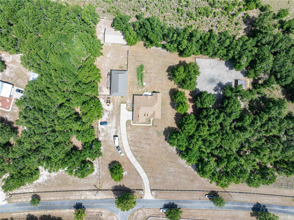 An aerial view shows a house with a driveway, detached garage, and surrounding wooded land — 15527 194TH PLACE, O'BRIEN, FL