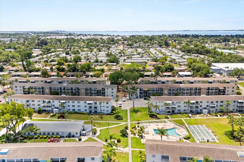 An aerial view shows apartment buildings, a swimming pool, and surrounding residential neighborhoods — 2425 FLAMINGO BOULEVARD UNIT K28, BRADENTON, FL