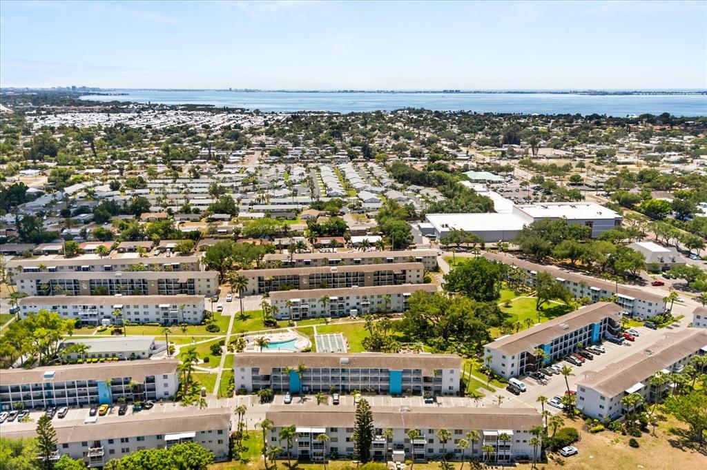 An aerial view shows several multi-story apartment buildings surrounded by trees and parking lots — 2425 FLAMINGO BOULEVARD UNIT K28, BRADENTON, FL