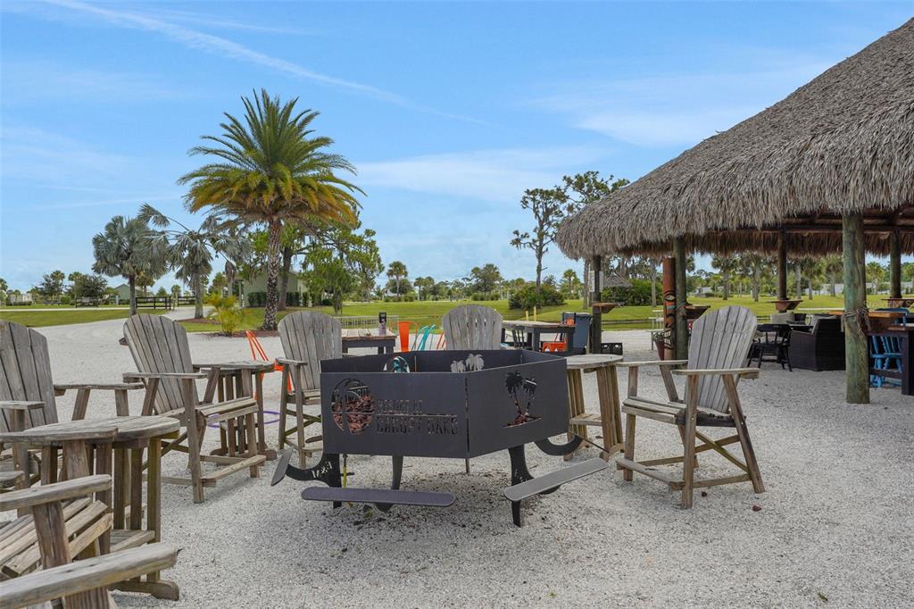 An outdoor seating area with wooden chairs surrounding a metal fire pit on gravel — 0 HIGHWAY 630 E UNIT 150, LAKE WALES, FL