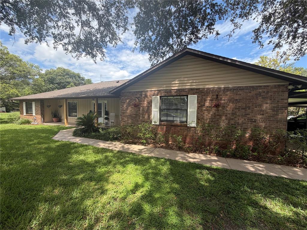 A single-story brick and siding house with a covered porch and a concrete walkway — 5915 SHERYL ANITA STREET, OVIEDO, FL
