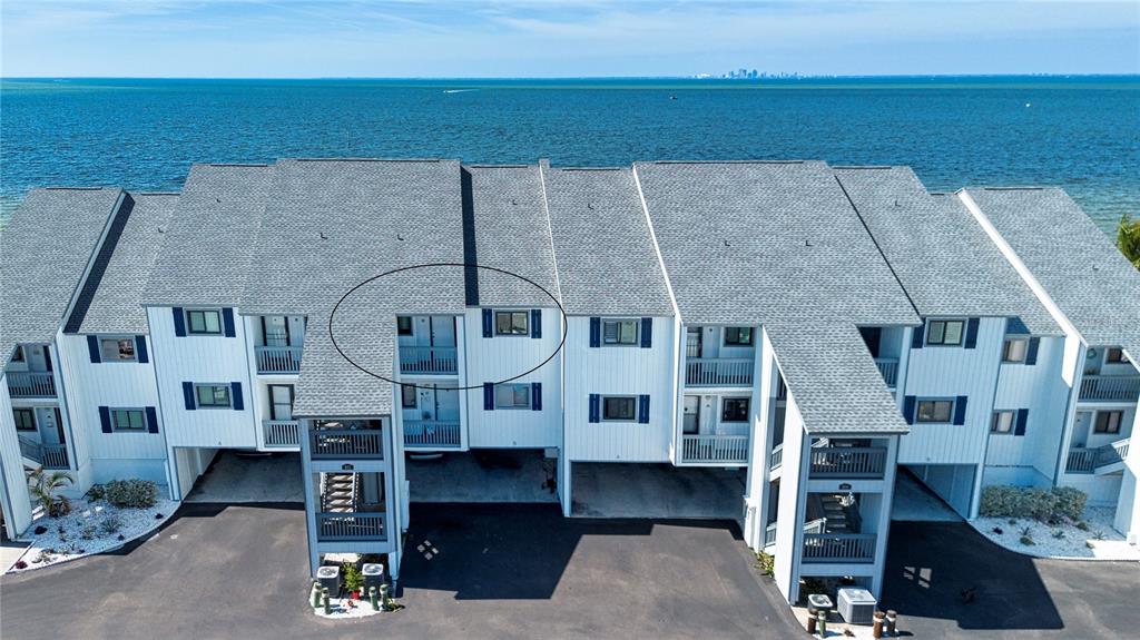 An aerial view of a multi-story waterfront condominium building with white siding and shingled roofs — 802 BAHIA DEL SOL DRIVE UNIT 6, RUSKIN, FL