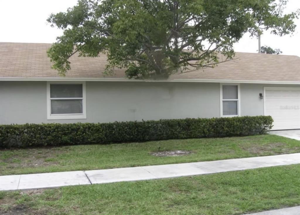 A single-story house with a light-colored exterior, a shingled roof, and a large tree in front — 1209 S DIXIE HIGHWAY, DELRAY BEACH, FL