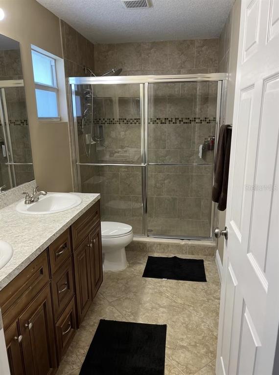A bathroom features a vanity with a white sink, a tiled shower, and tile flooring — 1209 S DIXIE HIGHWAY, DELRAY BEACH, FL