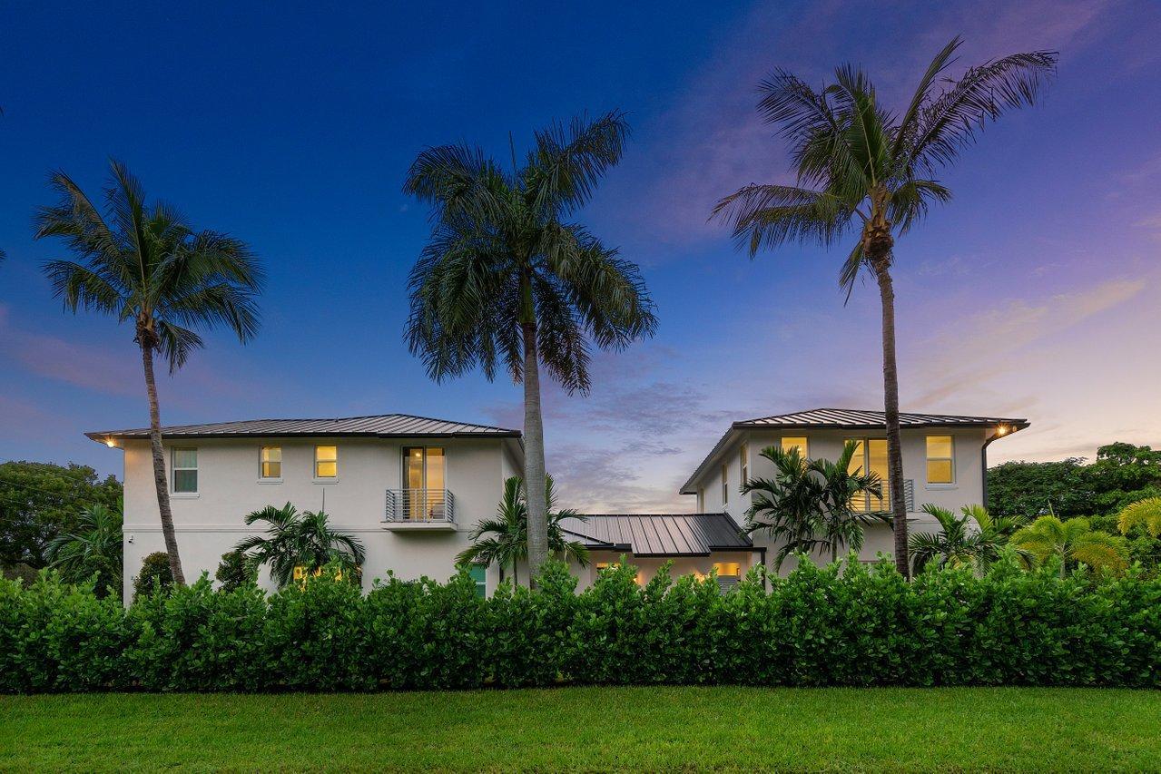 A two-story white house with a dark metal roof stands behind a manicured green hedge — 217 Gulfstream Boulevard, Boynton Beach FL 33435, BOYNTON BEACH, FL