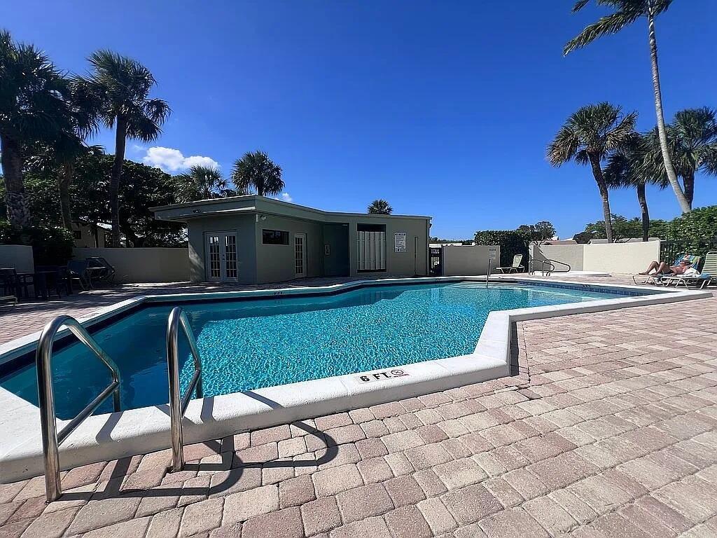 A rectangular swimming pool with a paved deck and a small utility building behind it — 6463 La Costa Drive # 105, Boca Raton FL 33433, BOCA RATON, FL