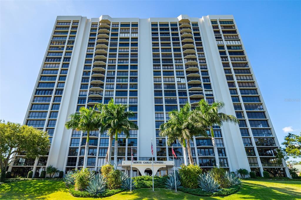 A low-angle exterior view of the tall, white Monte Carlo Towers apartment building — 3301 BAYSHORE BOULEVARD UNIT 1510A, TAMPA, FL