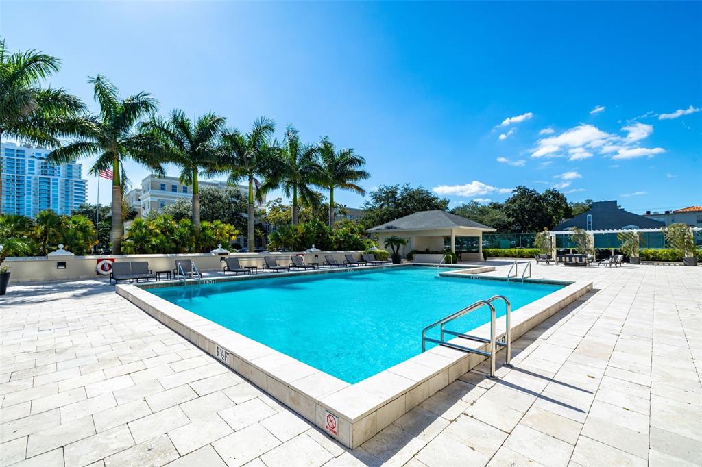 A rectangular swimming pool with a stone deck and palm trees under a blue sky — 3301 BAYSHORE BOULEVARD UNIT 1510A, TAMPA, FL