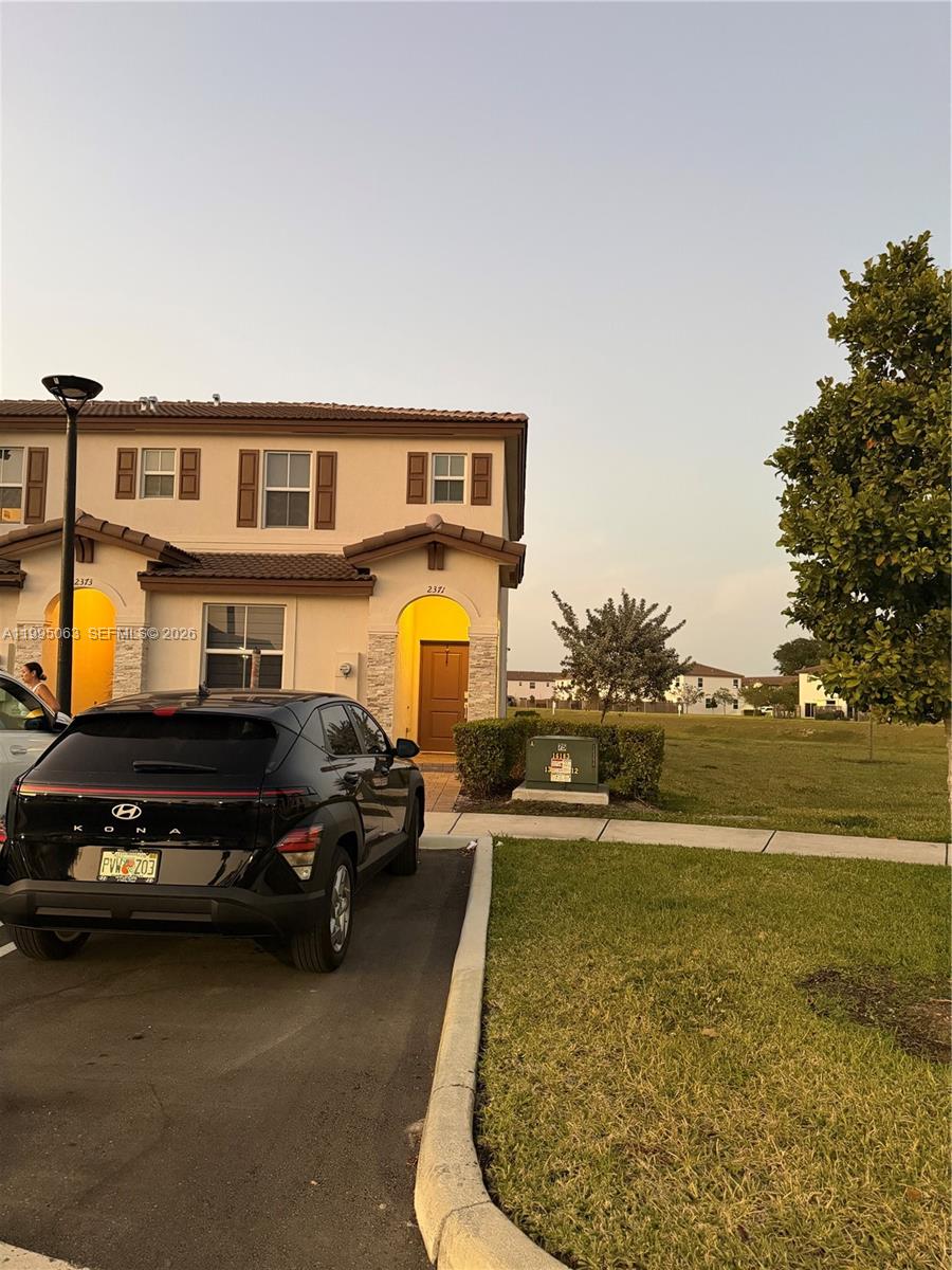 A two-story townhouse exterior with a black SUV parked in the driveway — 2371 NW 122nd Ter, Miami FL 33167, MIAMI, FL