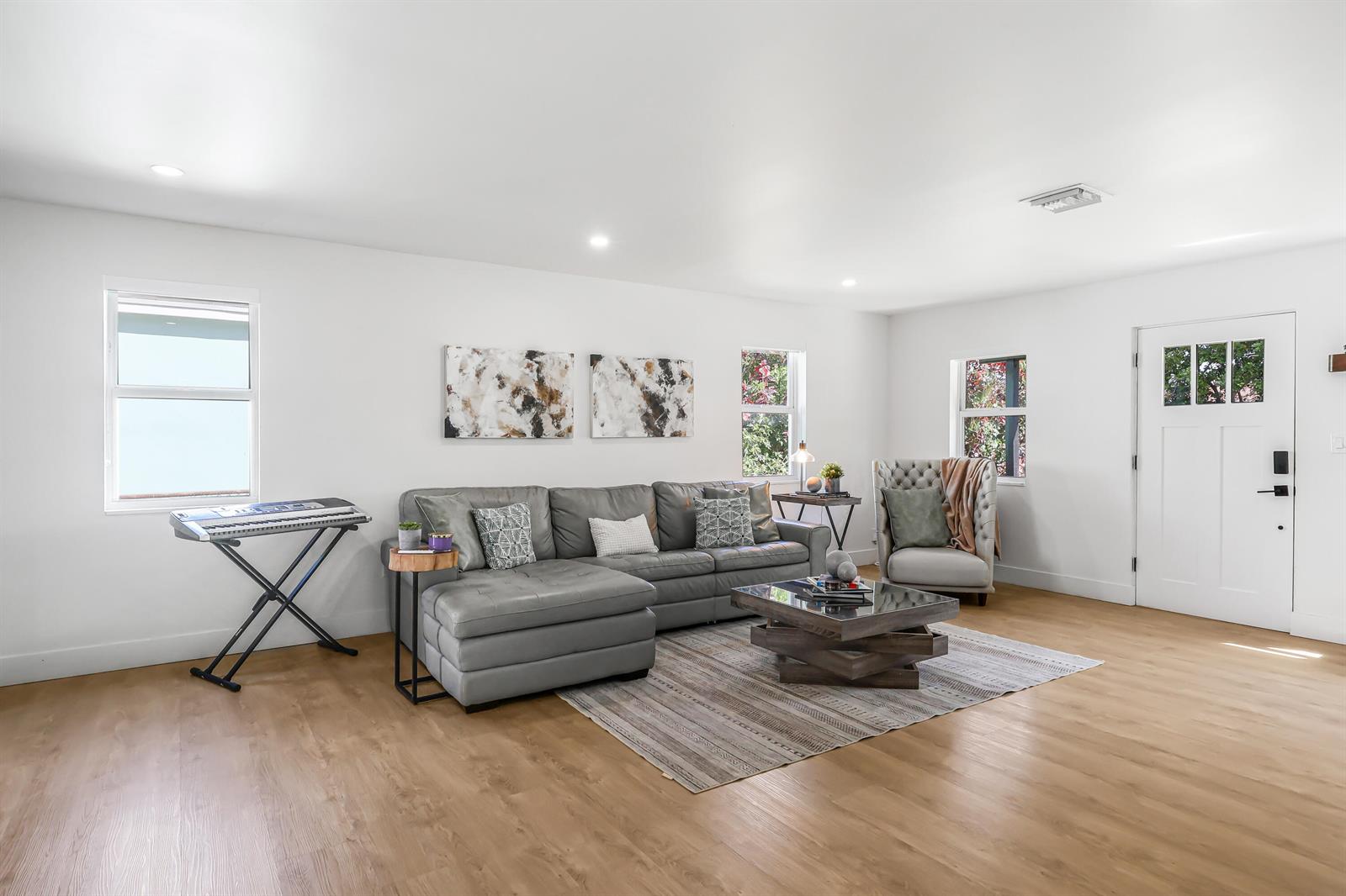 A living room features a gray sectional sofa, a coffee table, and light wood flooring — 1125 N K Street, FL 33460, FL