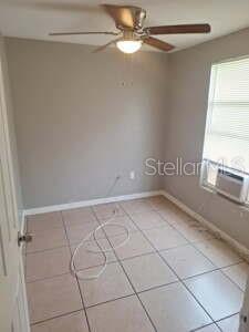 A small room with light gray walls, tiled flooring, a ceiling fan, and a window unit — 1900 BAYSHORE ROAD UNIT C, PALMETTO, FL