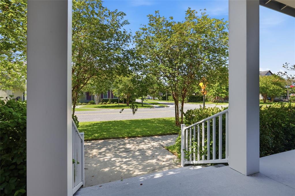 A view from a covered porch looking out toward a residential street and trees — 8105 LAUREATE BOULEVARD, ORLANDO, FL