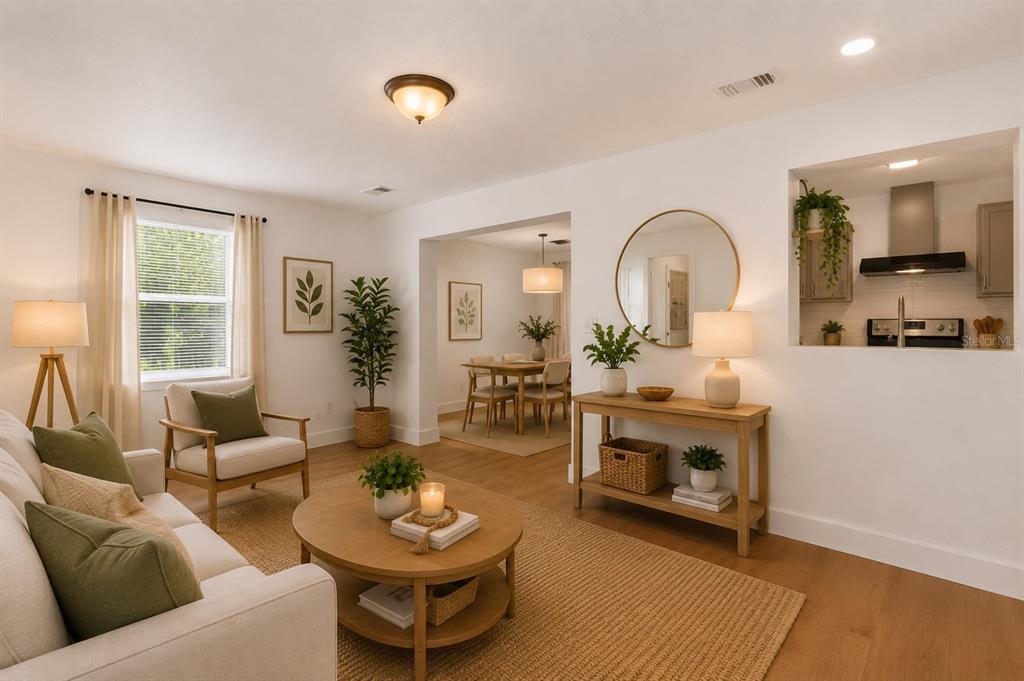 A living room with light wood floors, a round coffee table, and an open kitchen pass-through — 5557 CLEVELAND ROAD, JACKSONVILLE, FL
