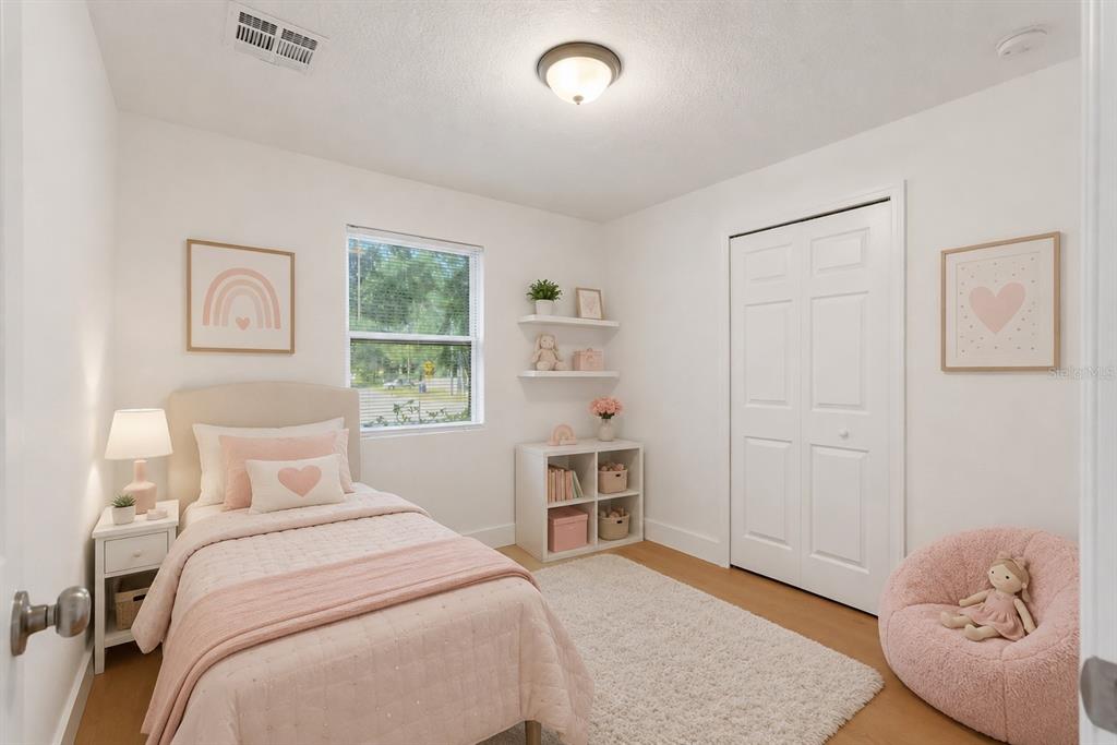 A bedroom features a twin bed, white furniture, pink decor, and a plush beanbag chair — 5557 CLEVELAND ROAD, JACKSONVILLE, FL