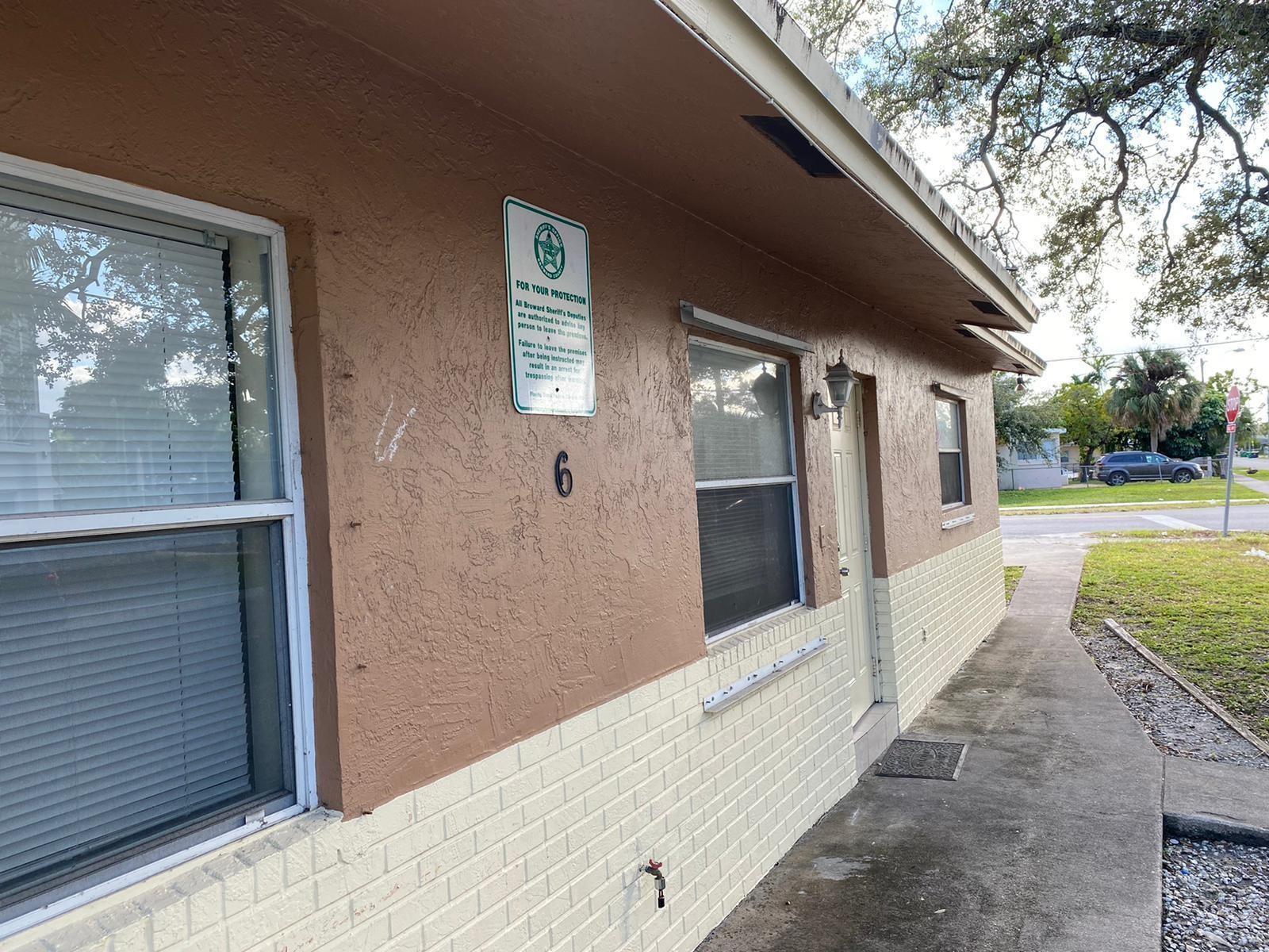 Exterior view of a tan and cream-colored building with a numbered unit entrance — 6 SW 7th Avenue, Dania Beach FL 33004, DANIA BEACH, FL