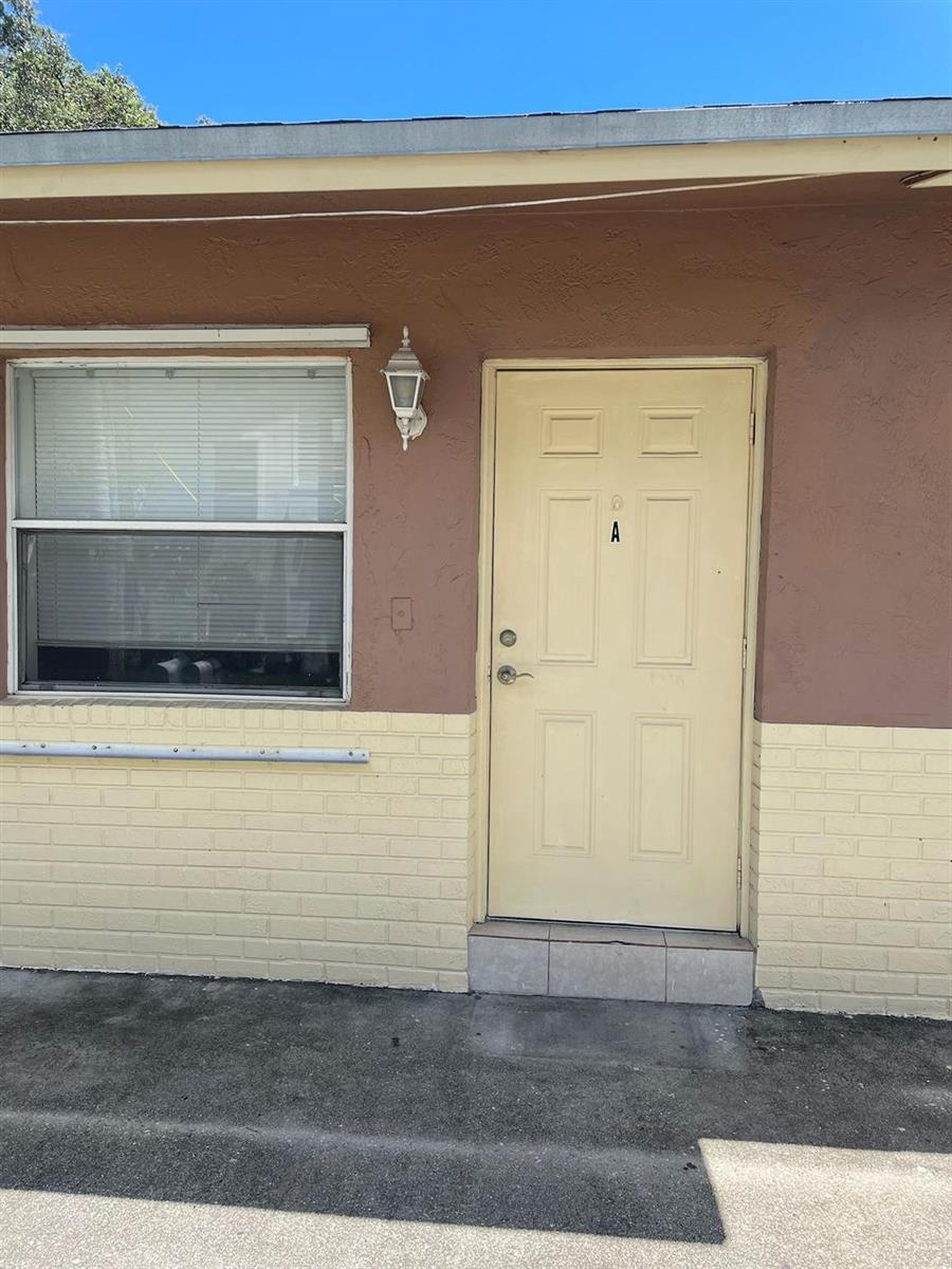 The exterior of a building features a light-colored door labeled A and a window — 6 SW 7th Avenue, Dania Beach FL 33004, DANIA BEACH, FL