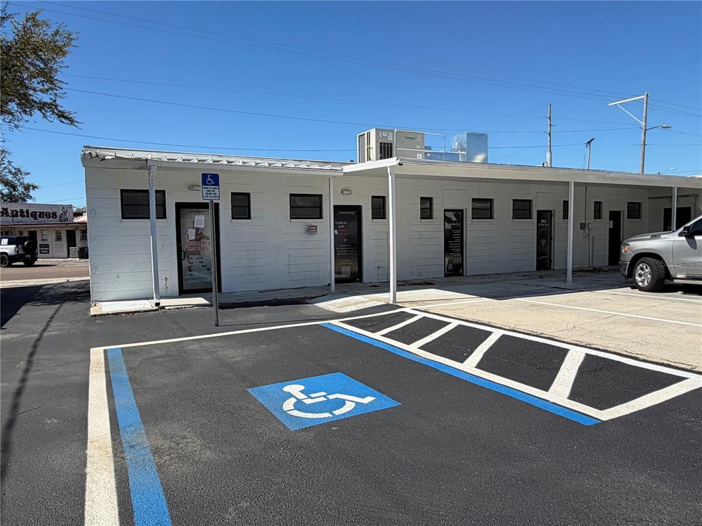 A single-story commercial building with white block walls sits on a corner lot — 3418 W SWANN AVENUE UNIT 200, TAMPA, FL