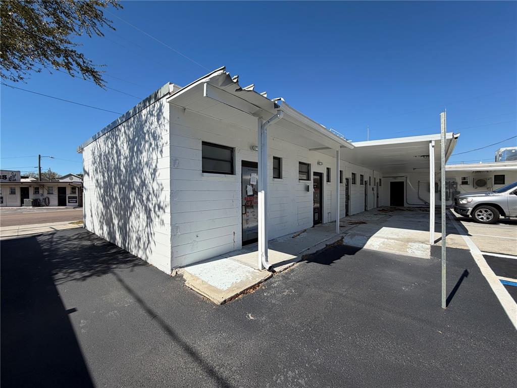 A white commercial building features a handicap-accessible parking space in the foreground — 3418 W SWANN AVENUE UNIT 200, TAMPA, FL