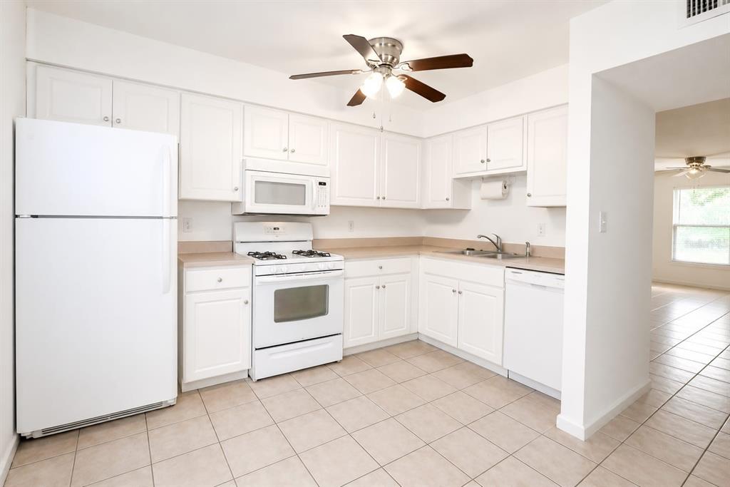 A kitchen with white cabinets, white appliances, and light-colored tile flooring — 5850 CYPRESS GARDENS BOULEVARD UNIT 608, WINTER HAVEN, FL