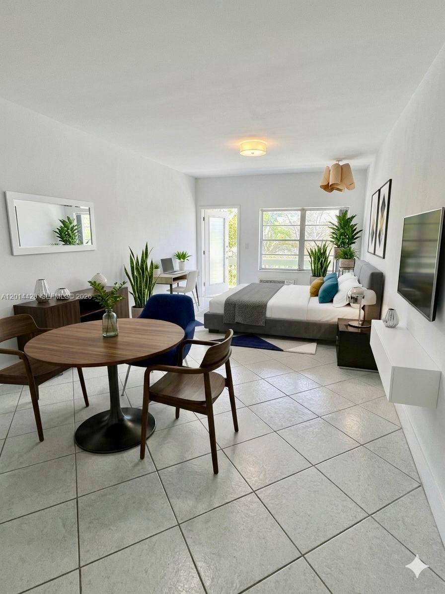 A studio apartment features a dining area, a bed, and a desk on tiled floors — 6490 Collins Ave # 14, Miami Beach FL 33141, MIAMI BEACH, FL