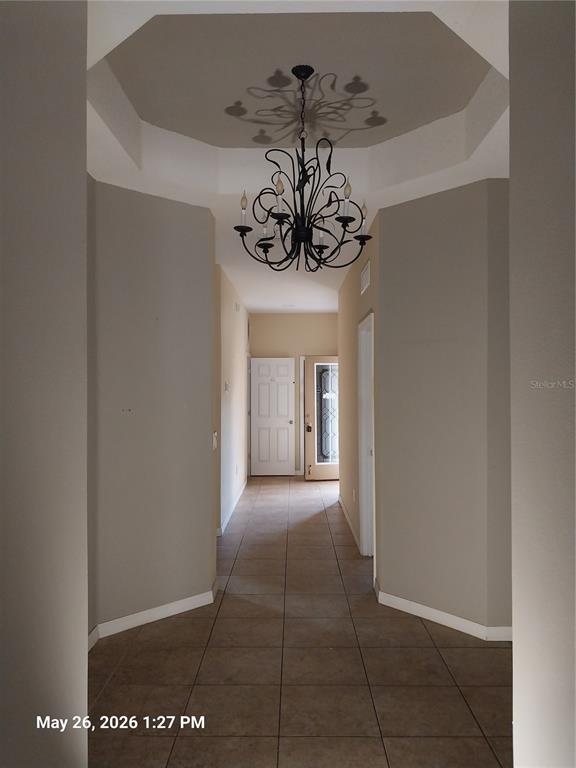 A tiled hallway features a decorative chandelier hanging from a recessed octagonal ceiling — 2228 PARROT FISH DRIVE, HOLIDAY, FL