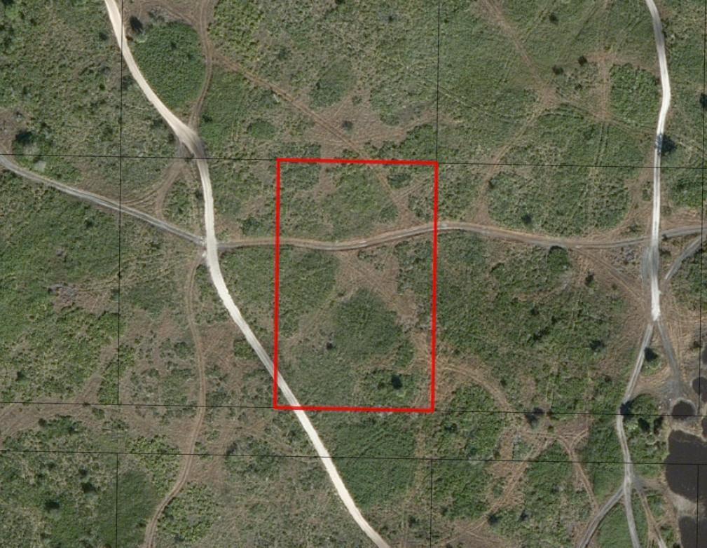 An aerial view shows a rectangular plot of land outlined in red amidst grassy terrain — 0 NW 318th Street, Okeechobee FL 34972, OKEECHOBEE, FL