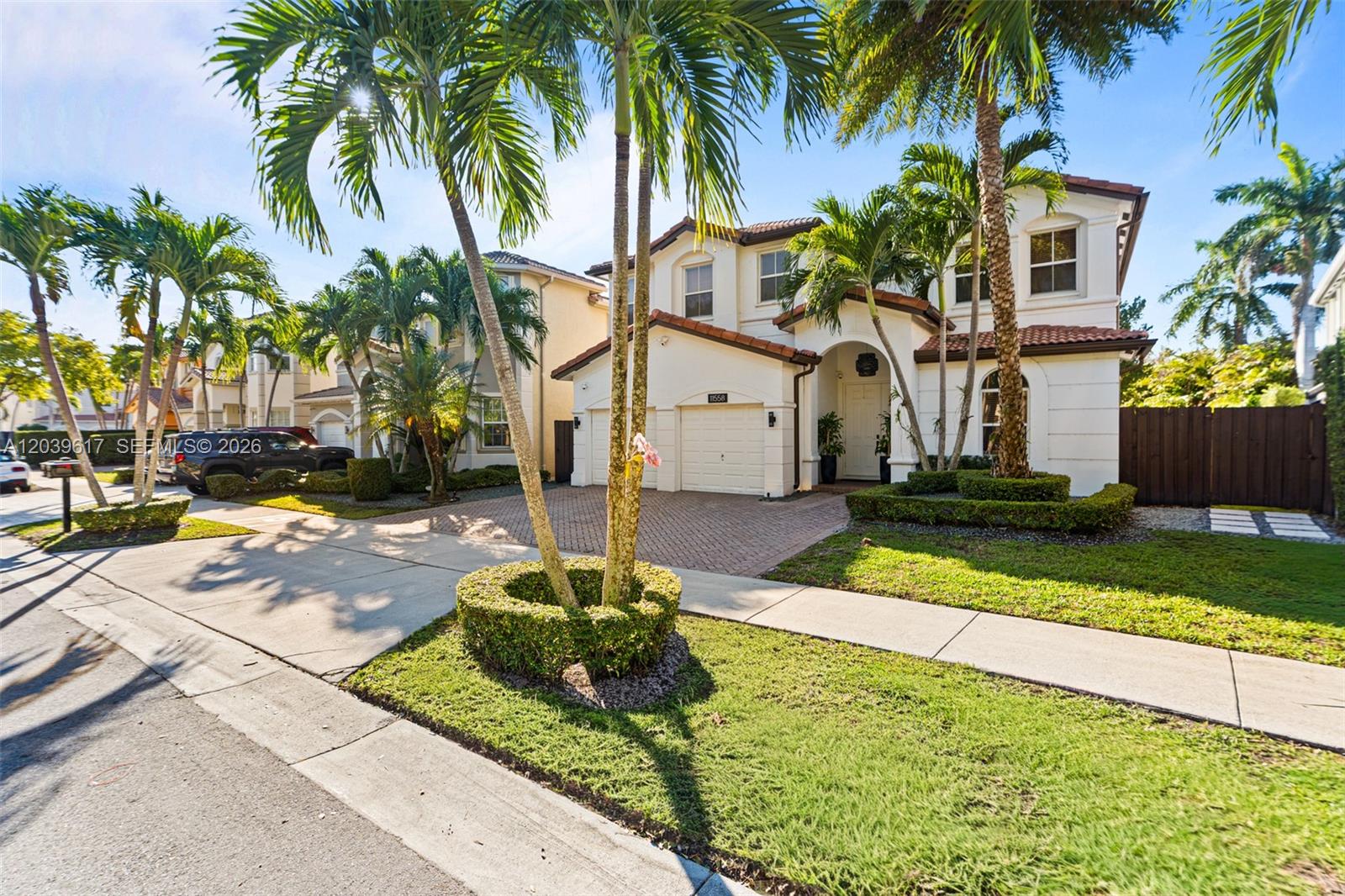 A two-story stucco house with a tiled roof, palm trees, and a paved driveway — 11558 NW 84th  St, Doral FL 33178, DORAL, FL