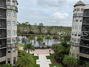 An elevated view of a courtyard with palm trees and a pond between two buildings — 14501 GROVE RESORT AVE UNIT 1535, WINTER GARDEN, FL