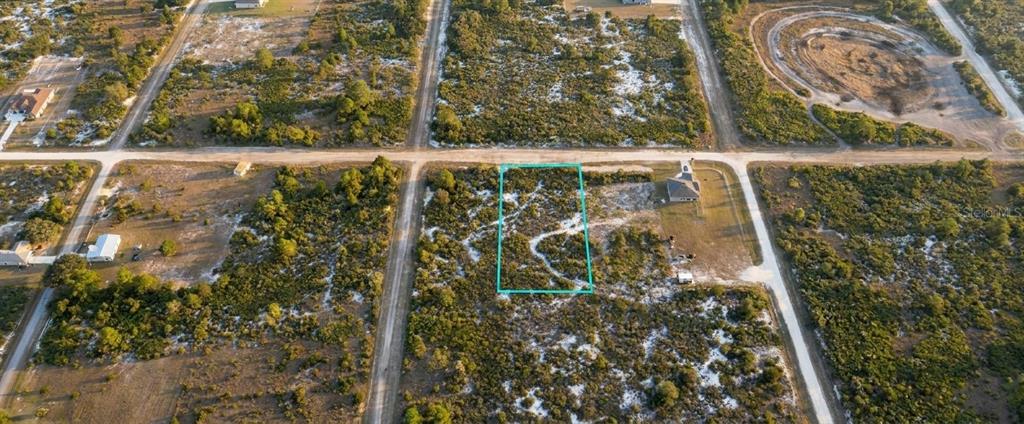An aerial view shows a vacant, rectangular lot outlined in teal within a rural subdivision — 1028 S LANDRY ROAD, AVON PARK, FL