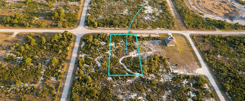An aerial view shows a rectangular vacant lot outlined in blue within a rural subdivision — 1028 S LANDRY ROAD, AVON PARK, FL