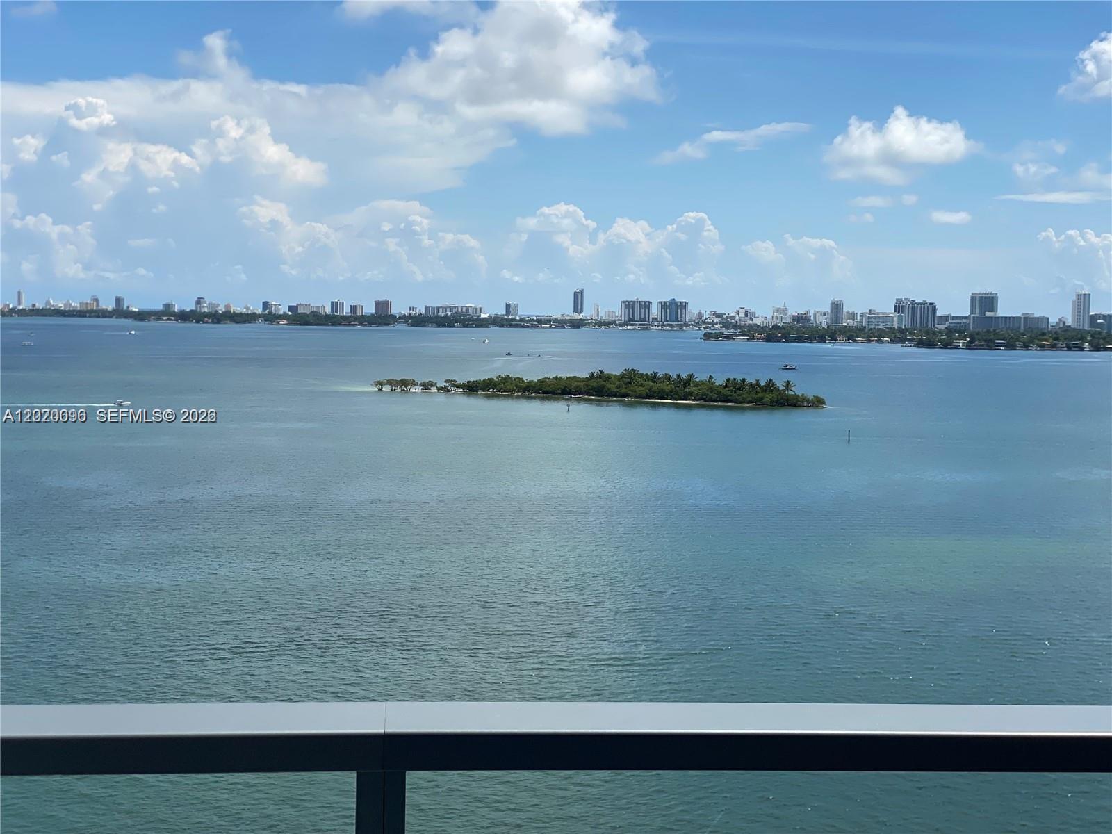 A balcony view overlooks a large body of water with a small island and skyline — 788 NE 23rd St # 1202, Miami FL 33137, MIAMI, FL