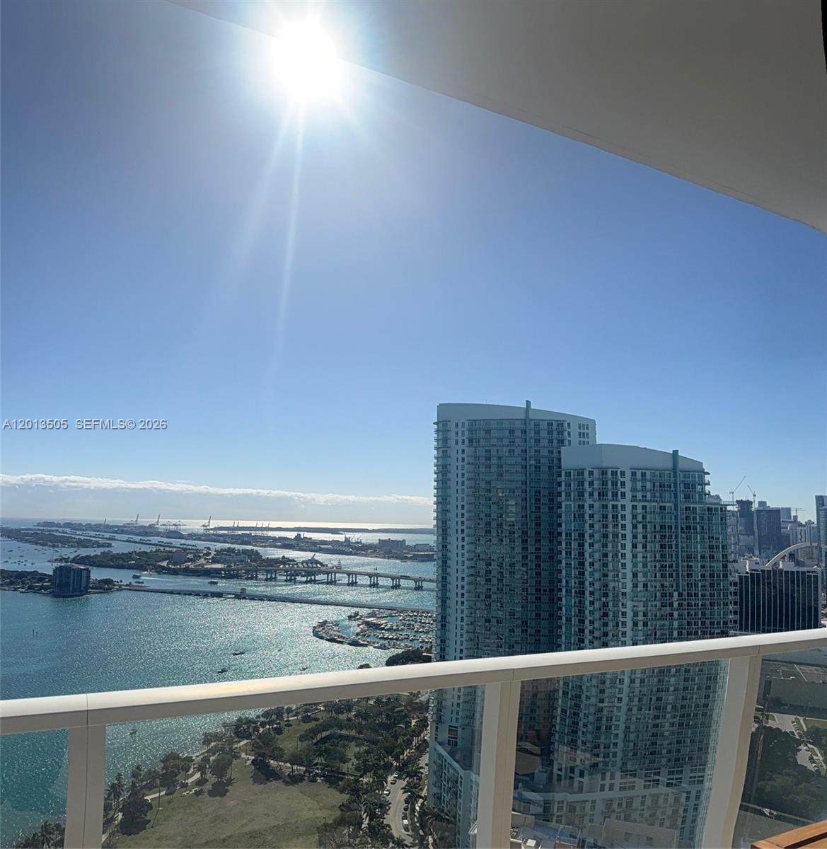 A high-angle view from a balcony overlooking a bay, bridges, and city skyscrapers — 2020 N Bayshore Dr # 3804, Miami FL 33137, MIAMI, FL