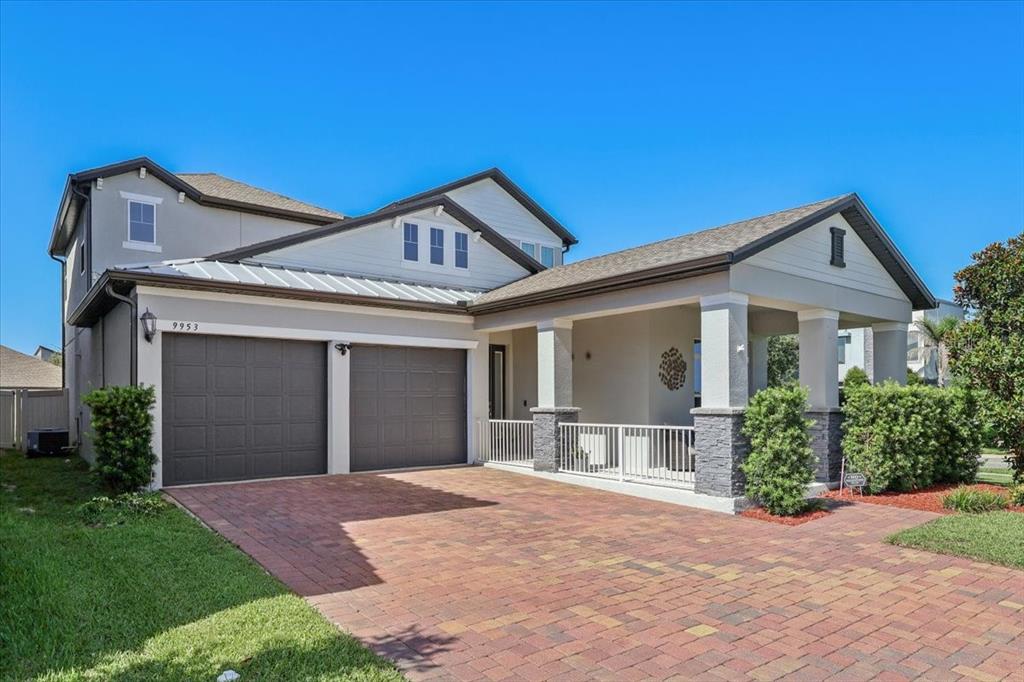 A two-story house with a brick paver driveway, a two-car garage, and a front porch — 9953 SUMMERLAKE GROVES STREET, WINTER GARDEN, FL