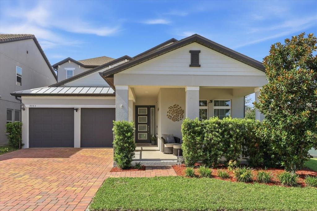 A single-story house with a two-car garage, a covered entryway, and a brick paver driveway — 9953 SUMMERLAKE GROVES STREET, WINTER GARDEN, FL
