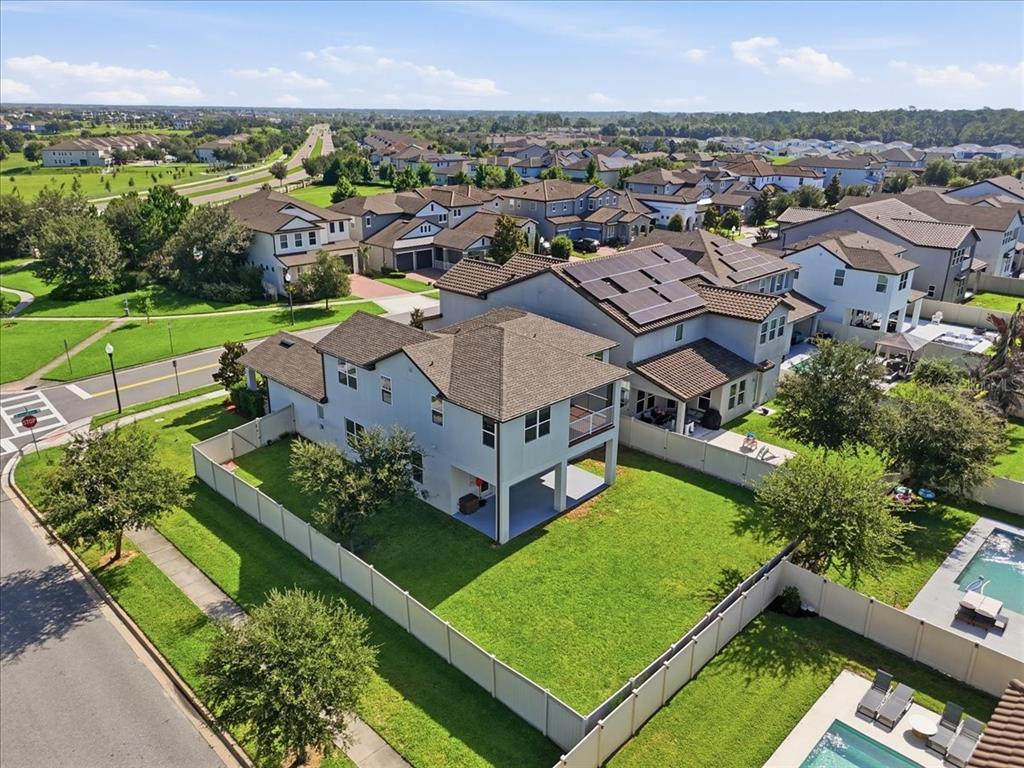 An aerial view shows a two-story house with a fenced backyard and solar panels — 9953 SUMMERLAKE GROVES STREET, WINTER GARDEN, FL