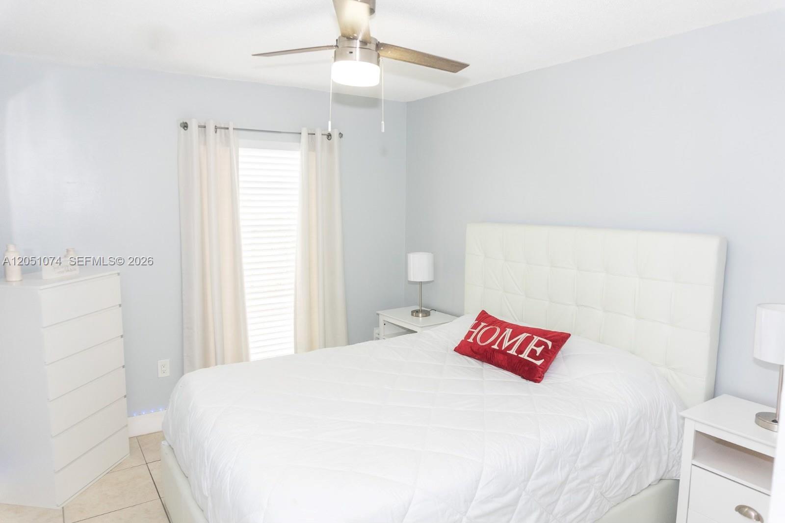 A bedroom features a white tufted headboard, a ceiling fan, and light blue walls — 6190 W 19th Ave # 201, Hialeah FL 33012, HIALEAH, FL