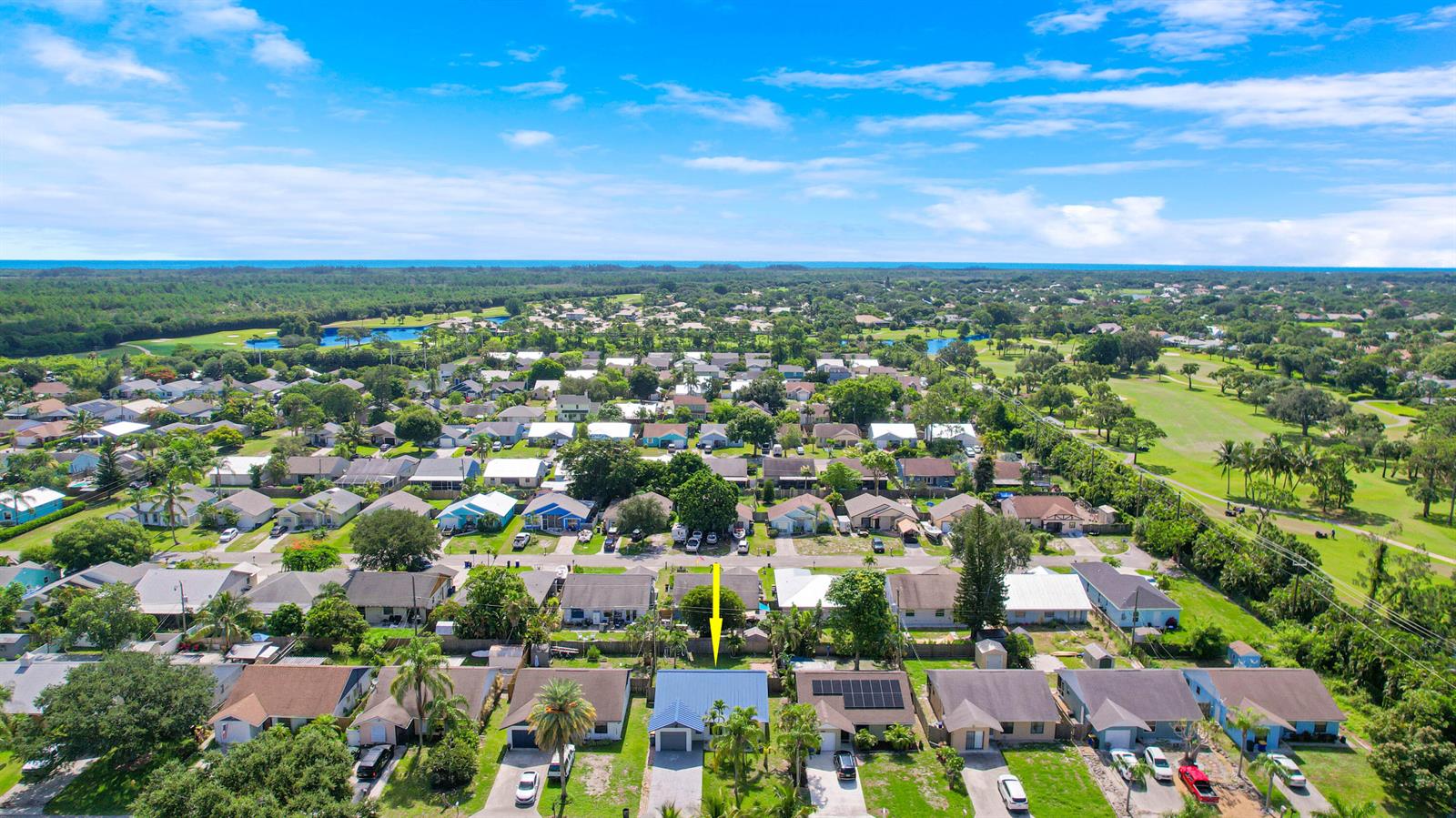 An aerial view shows a residential neighborhood with a single-story house highlighted by a yellow arrow — 5929 SE Collins Avenue, Stuart FL 34997, STUART, FL