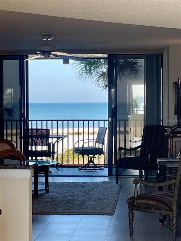 A living room with tile floors opens to a balcony overlooking the ocean — 1290 GULF BOULEVARD UNIT 302, CLEARWATER, FL