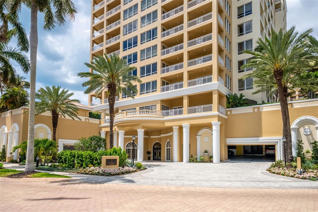 The exterior of a multi-story tan residential building features a covered entrance with white columns — 35 WATERGATE DRIVE UNIT 502, SARASOTA, FL