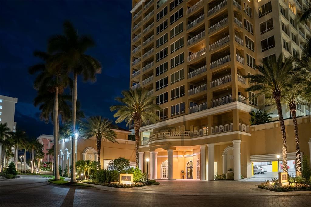 A multi-story building with a covered entrance, palm trees, and a paved driveway at night — 35 WATERGATE DRIVE UNIT 502, SARASOTA, FL