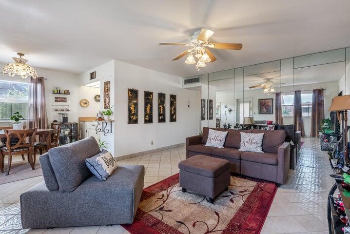 A living room features a gray sofa, a brown sectional, and a mirrored wall — 657 Brittany N, Delray Beach FL 33446, DELRAY BEACH, FL