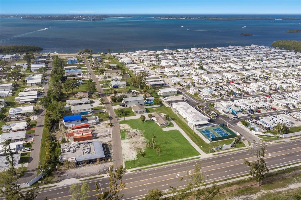 An aerial view shows a coastal mobile home park with a large vacant lot — 10601-10611 CORTEZ ROAD W, BRADENTON, FL