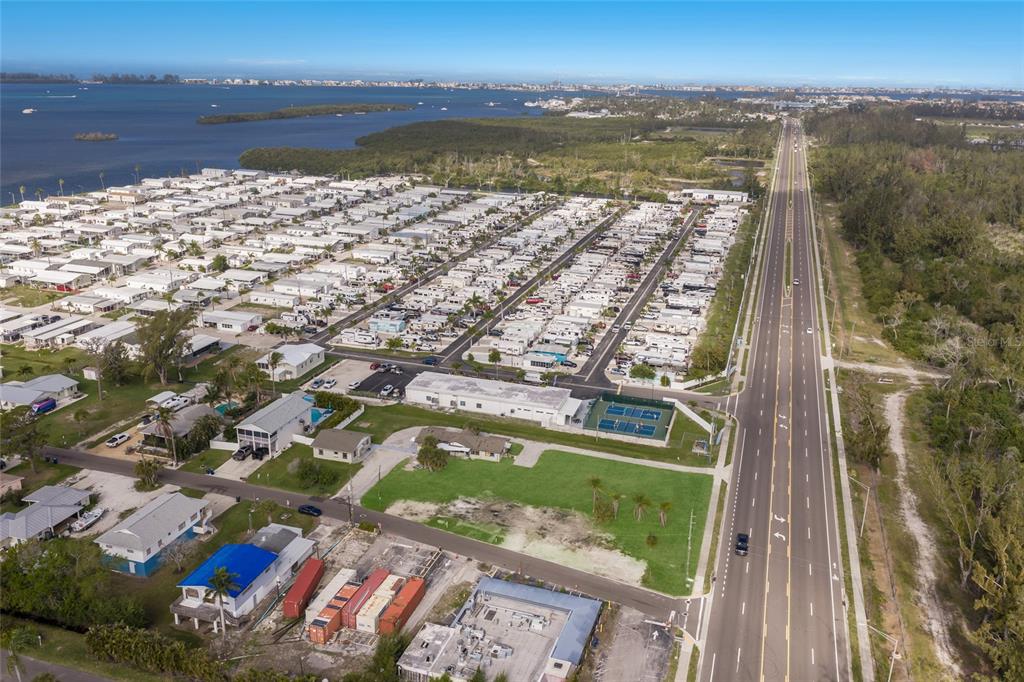 An aerial view shows a mobile home park located next to a highway and water — 10601-10611 CORTEZ ROAD W, BRADENTON, FL