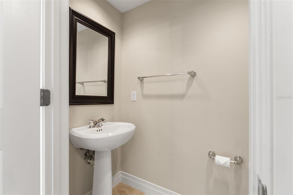 A small bathroom features a white pedestal sink, a dark-framed mirror, and a towel bar — 449 S 12TH STREET UNIT 2005, TAMPA, FL