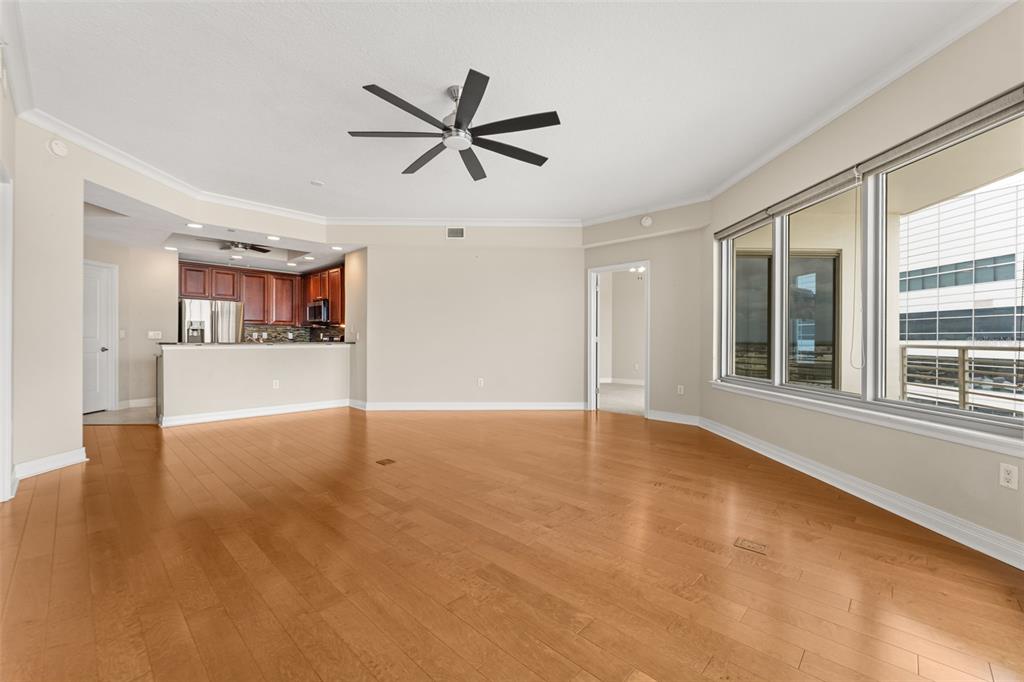 An empty living room with hardwood floors, a ceiling fan, and an open kitchen area — 449 S 12TH STREET UNIT 2005, TAMPA, FL