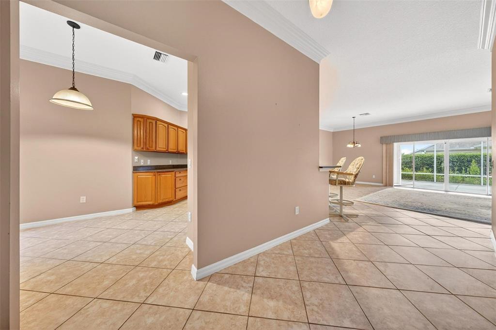 A view from a tiled entryway looking into a kitchen and a living area — 2612 MORVEN PARK WAY, THE VILLAGES, FL