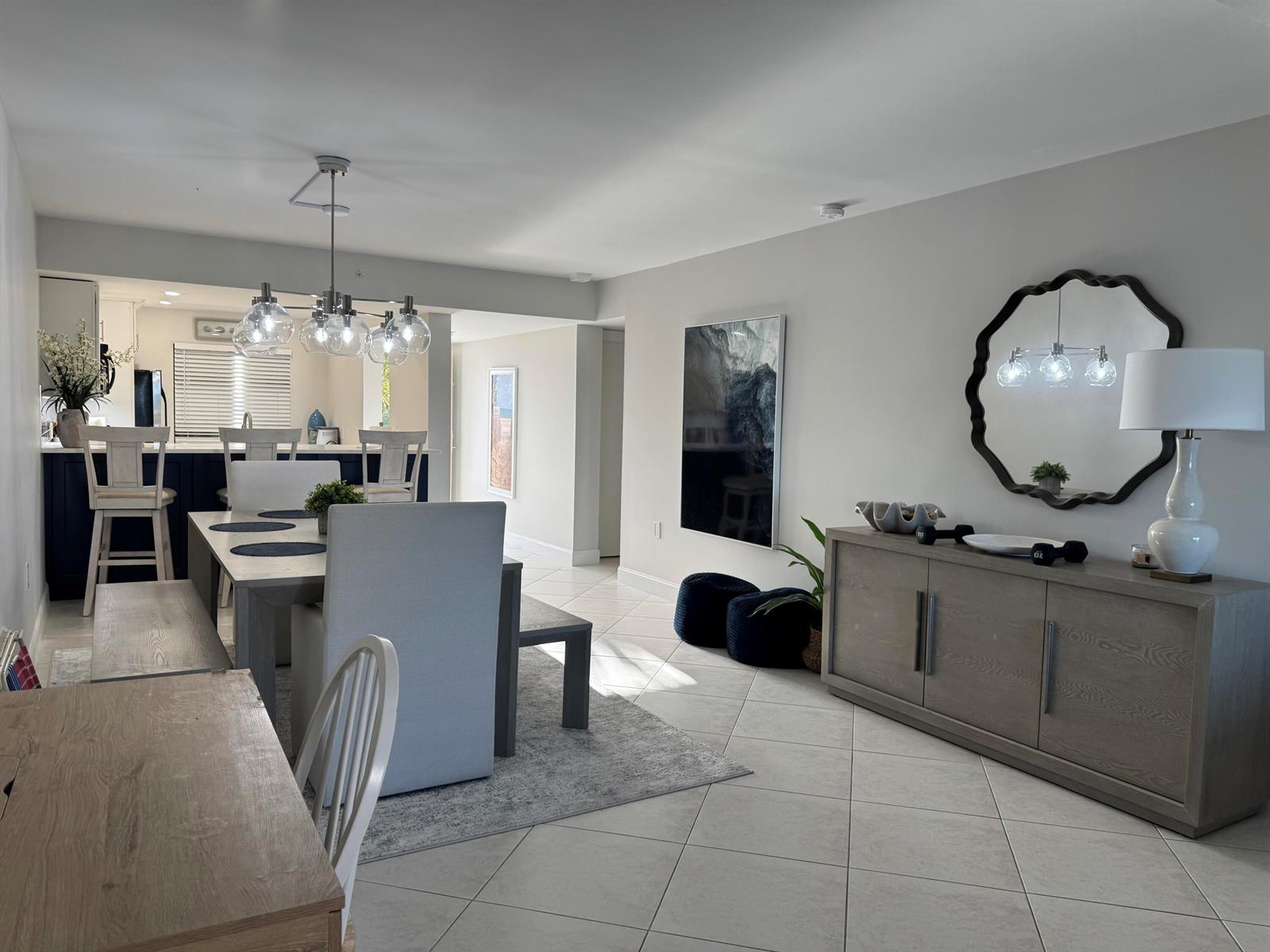 A dining area with a table, chairs, and a buffet cabinet sits near a kitchen — 401 Ocean Bluffs Boulevard # 303, Jupiter FL 33477, JUPITER, FL