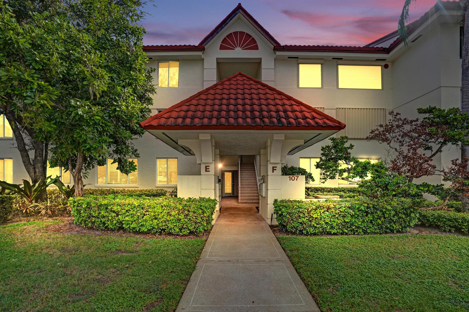 A multi-story apartment building exterior features a red tile roof and a central covered walkway — 107 Half Moon Circle # H1, Hypoluxo FL 33462, HYPOLUXO, FL